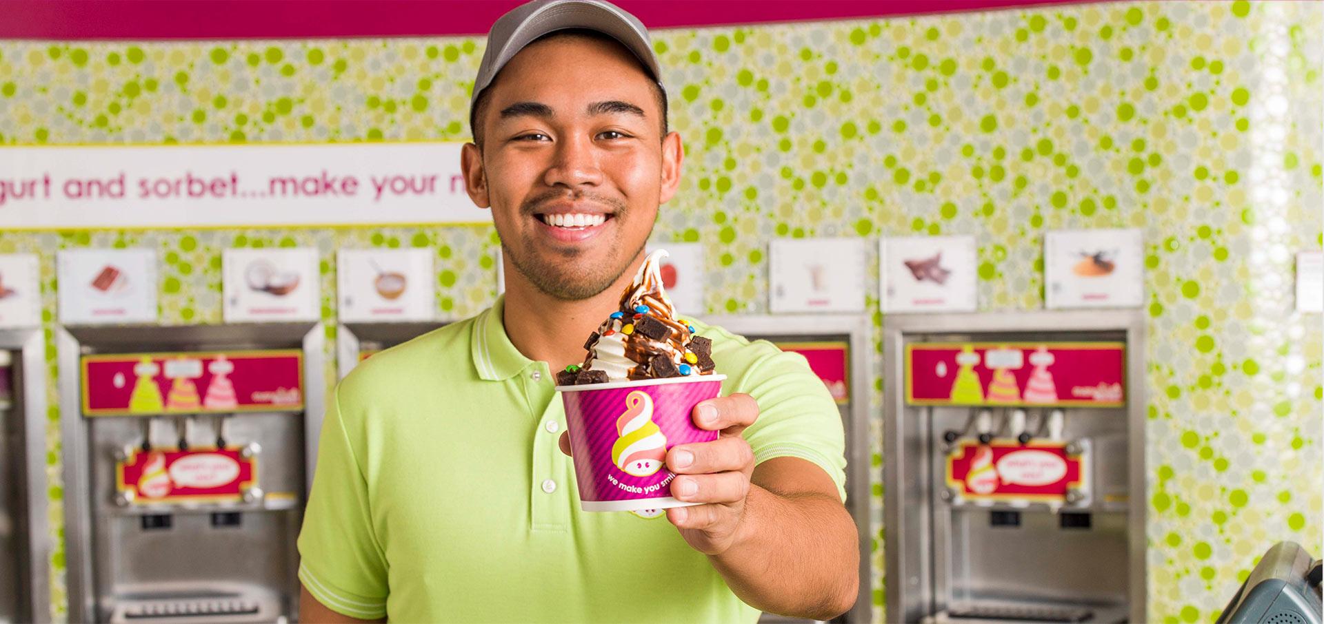 A Menchie's employee preparing toppings
