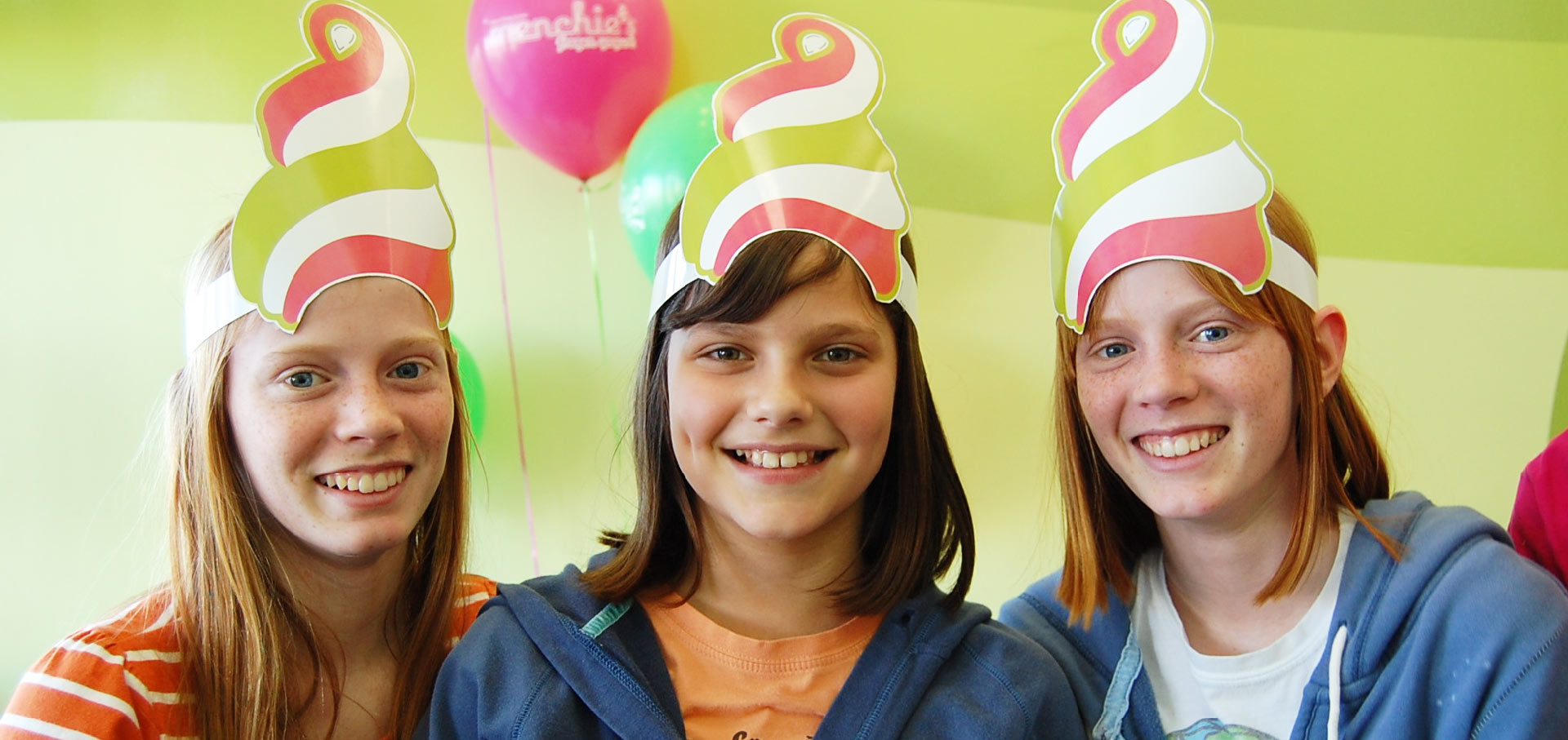 Three girls wearing Menchie's party hats