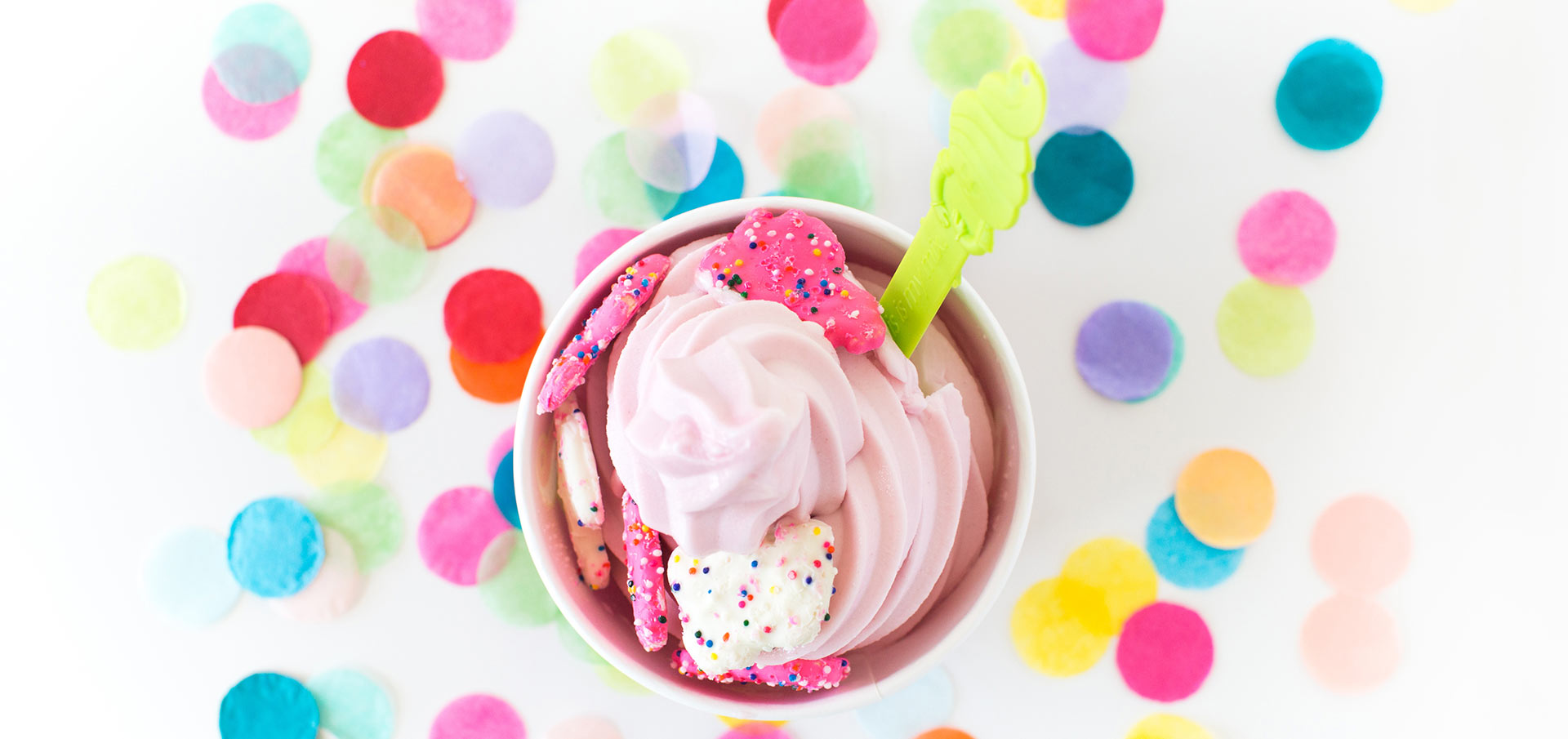 Two people scooping spoonfuls of Menchie's frozen yogurt